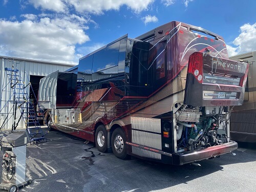 Bus Service & Repair | RDI Power in Brooksville, FL. Image of a red-black Prevost bus undergoing bus repair at RDI Power’s auto garage shop.