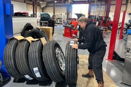 Mechanic at RDI Power handling new commercial tires for heavy duty diesel truck that came into the shop to get new tires installed.