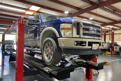 Light duty truck alignment in Brooksville, FL. at RDI Power. Image of blue light duty ford truck on alignment machine in shop bay.
