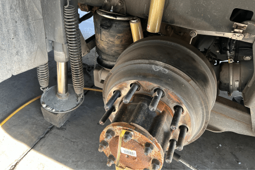 Semi truck brake repair near Brooksville, FL. Image of a brake rotor and the underside of a semi truck undergoing brake repair maintenance and replacement at RDI Power, showcasing the expertise and professionalism of the mechanics