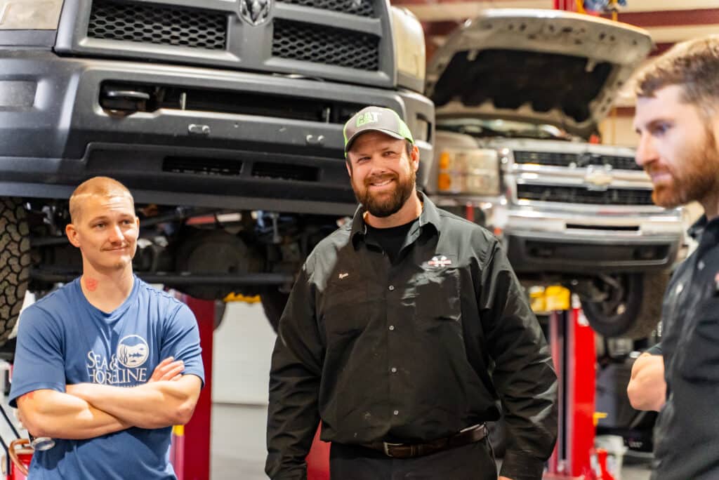 Light duty auto repair in Brooksville, FL by RDI Power. Image of a technician standing confidently in the shop with a light-duty truck lifted in the background, highlighting trusted repair services.
